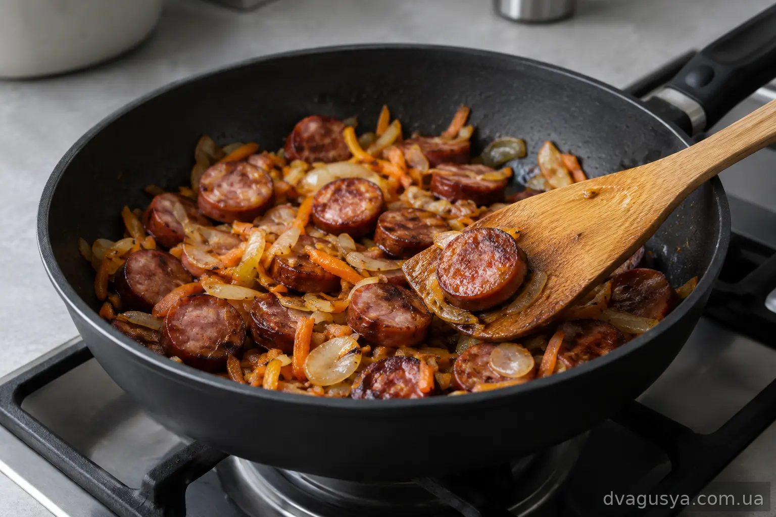 Обсмажені мисливські ковбаски з овочами на сковороді