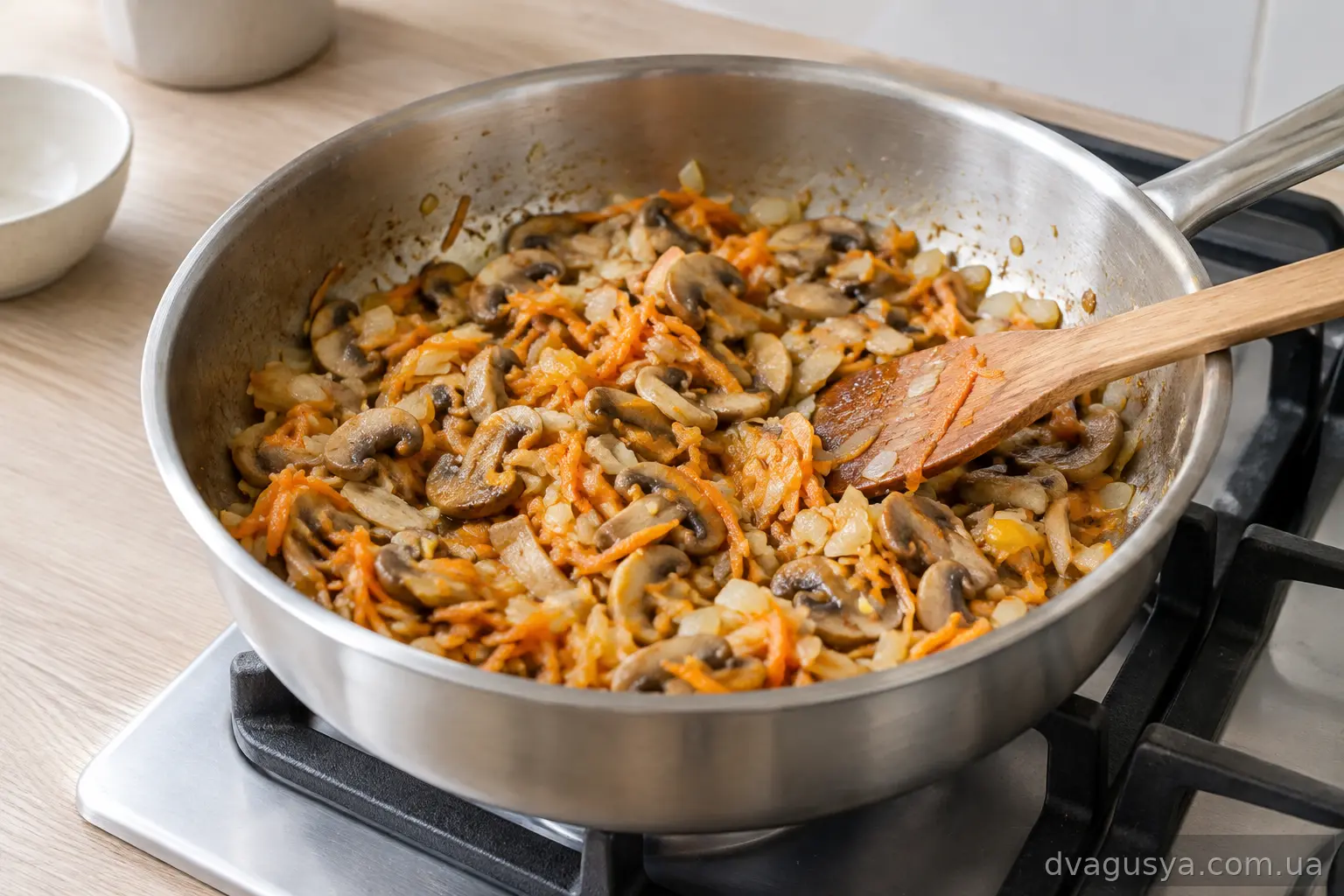 Цибуля, морква і слайси печериць тушкуються на сковороді