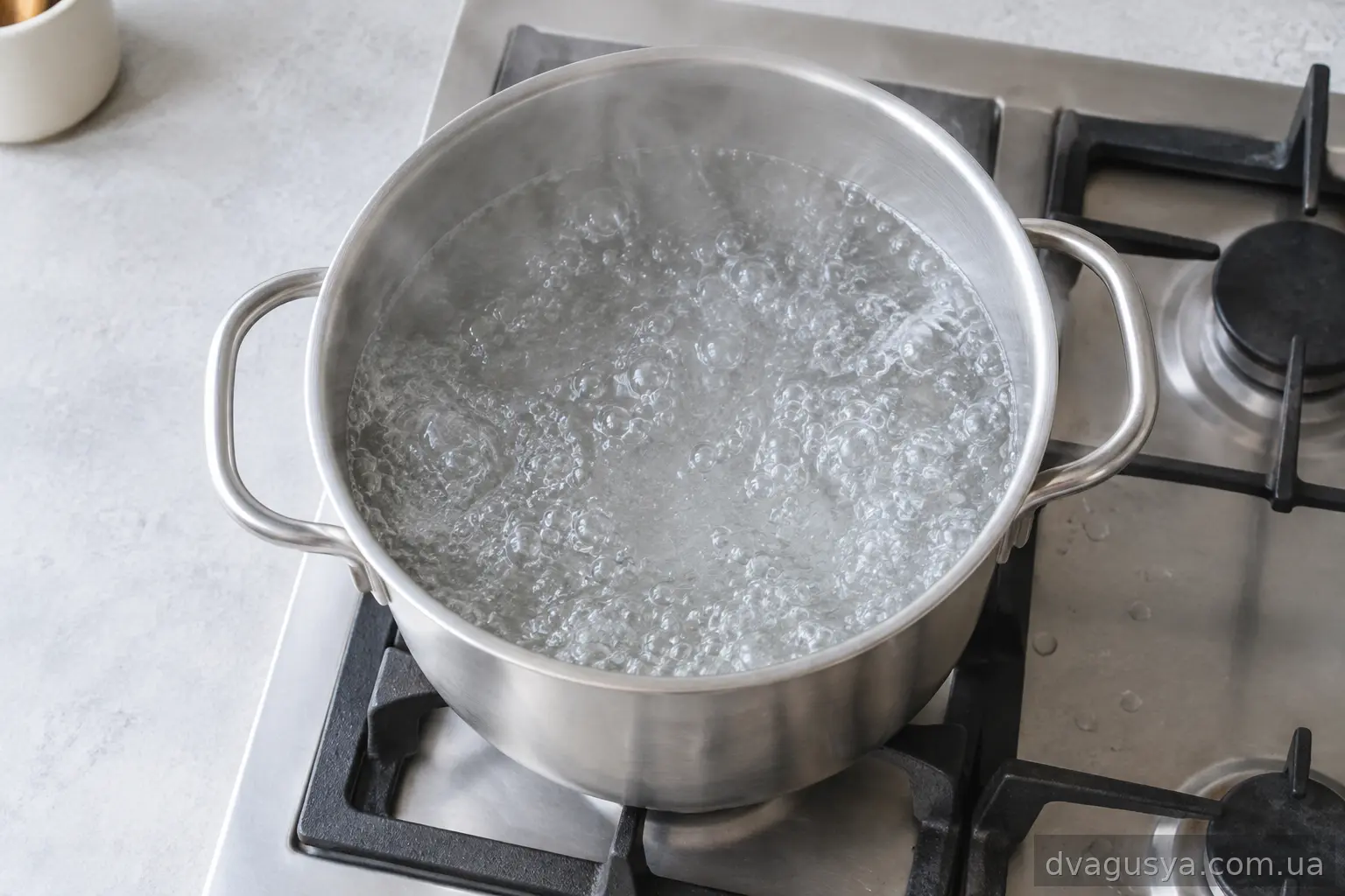 Велика каструля з киплячою водою на плиті