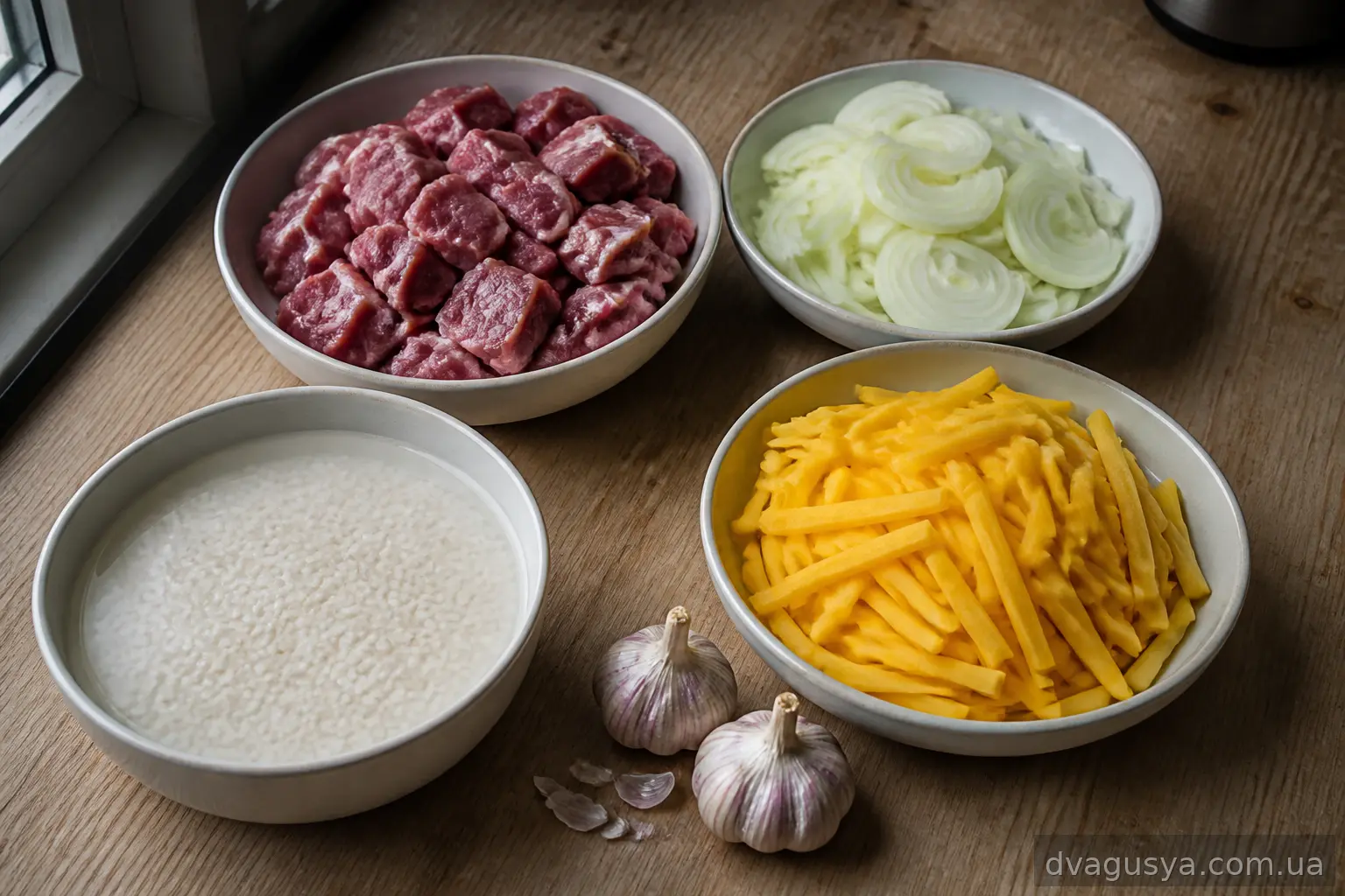 Підготовлені інгредієнти для плову: кубики баранини, півкільця цибулі, соломка моркви, промитий рис і головки часнику
